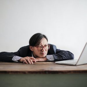 bored formal man watching laptop at desk