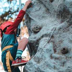 person climbing on gray rock